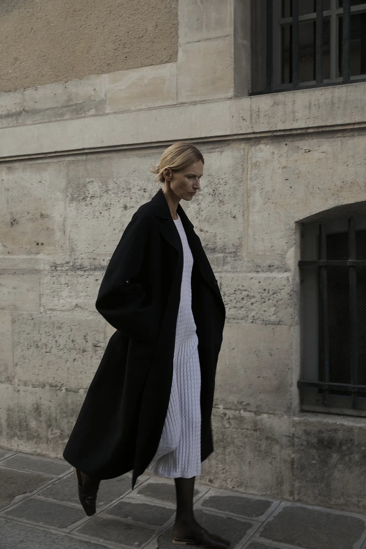 Long black coat reference showing a clean shoulder-to-hem line