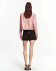 Pink lambskin cropped leather moto jacket back view on model