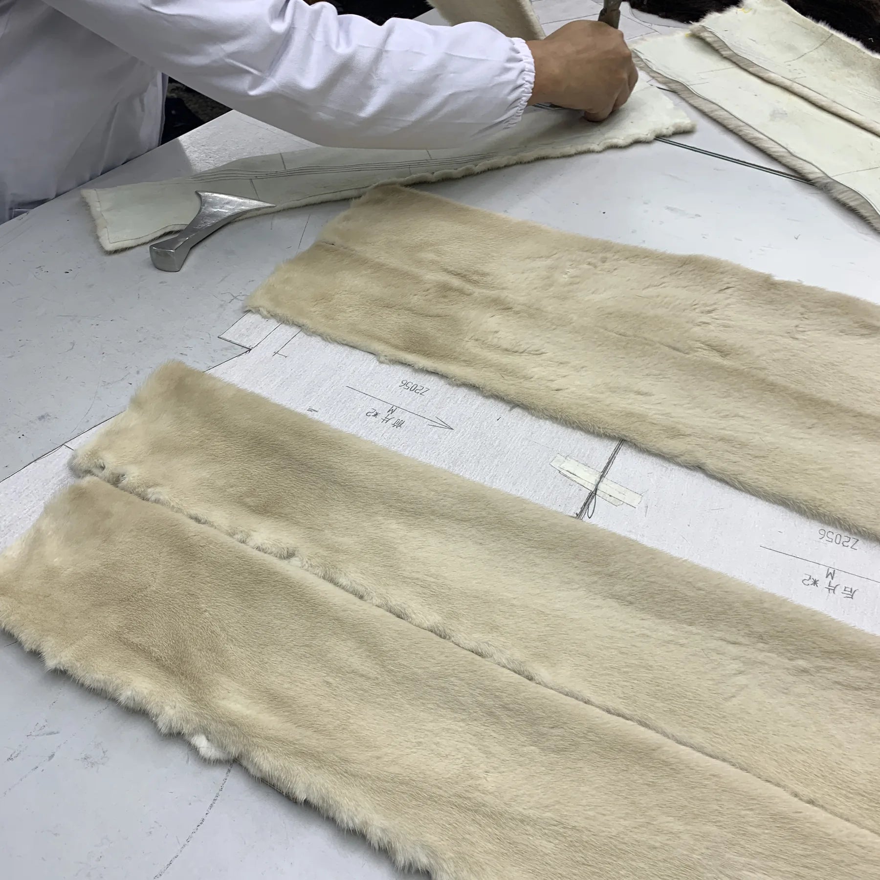 Fur panels and pattern pieces on a worktable used to show hidden buying problems and inspection points