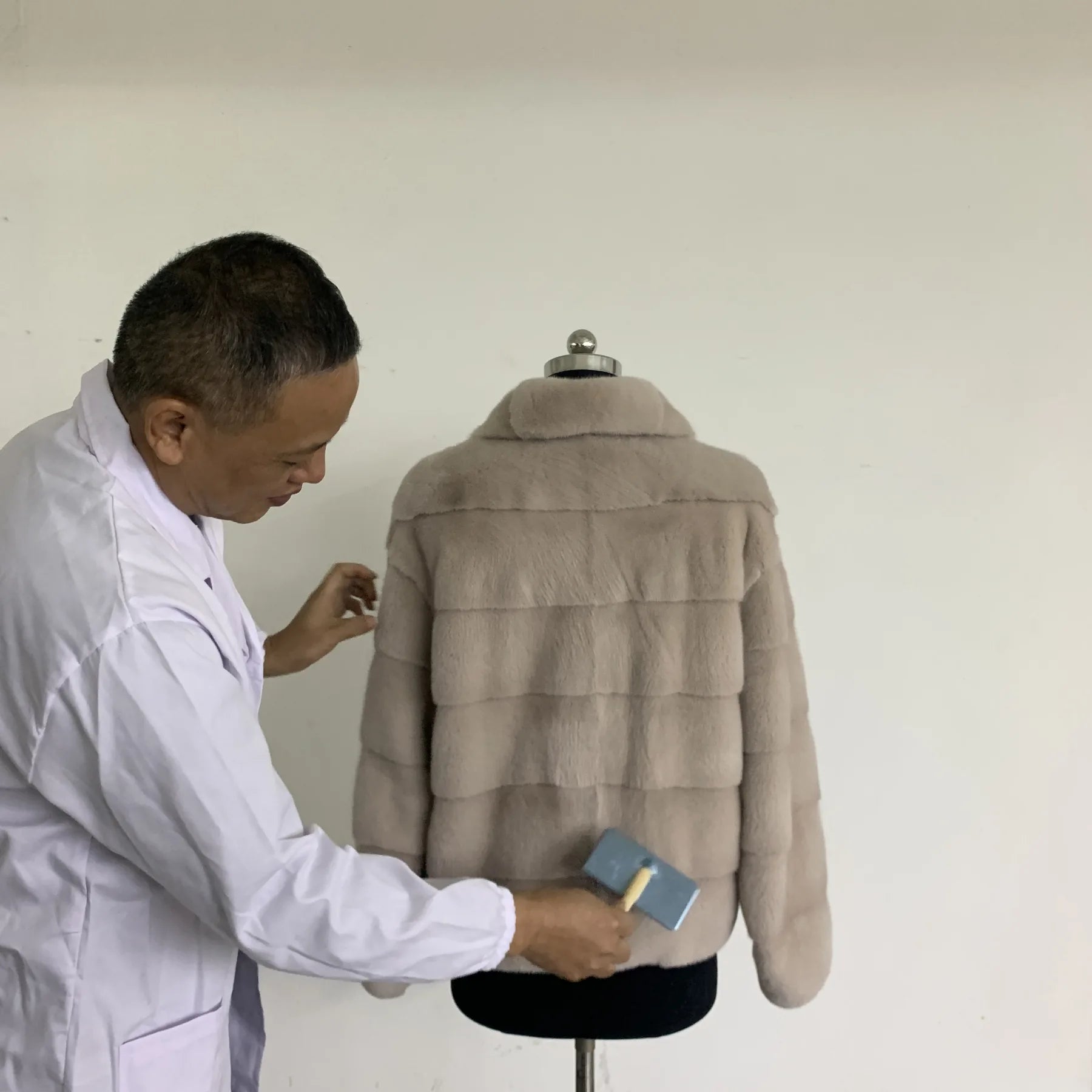 Fur coat on hanger used to explain moisture and weather risk before buying