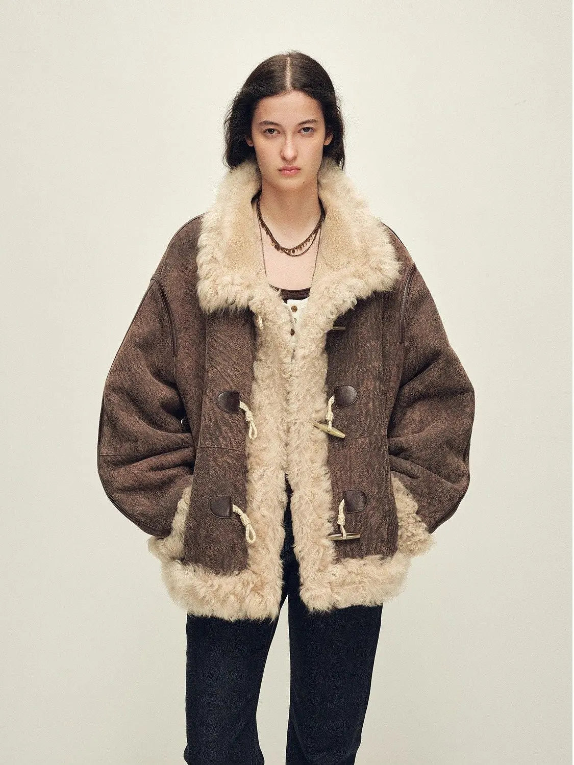 Model wearing the Galaxy Gala fog brown Merino shearling coat, front view