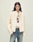 Woman wearing the Healing Eros white Toscana shearling coat, front styling view