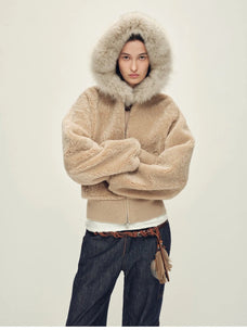 Model wearing Hokkaido Melody camel short hooded Merino shearling jacket with hood up