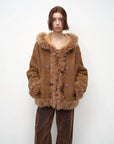 Model wearing the camel hooded Merino shearling jacket, view 1