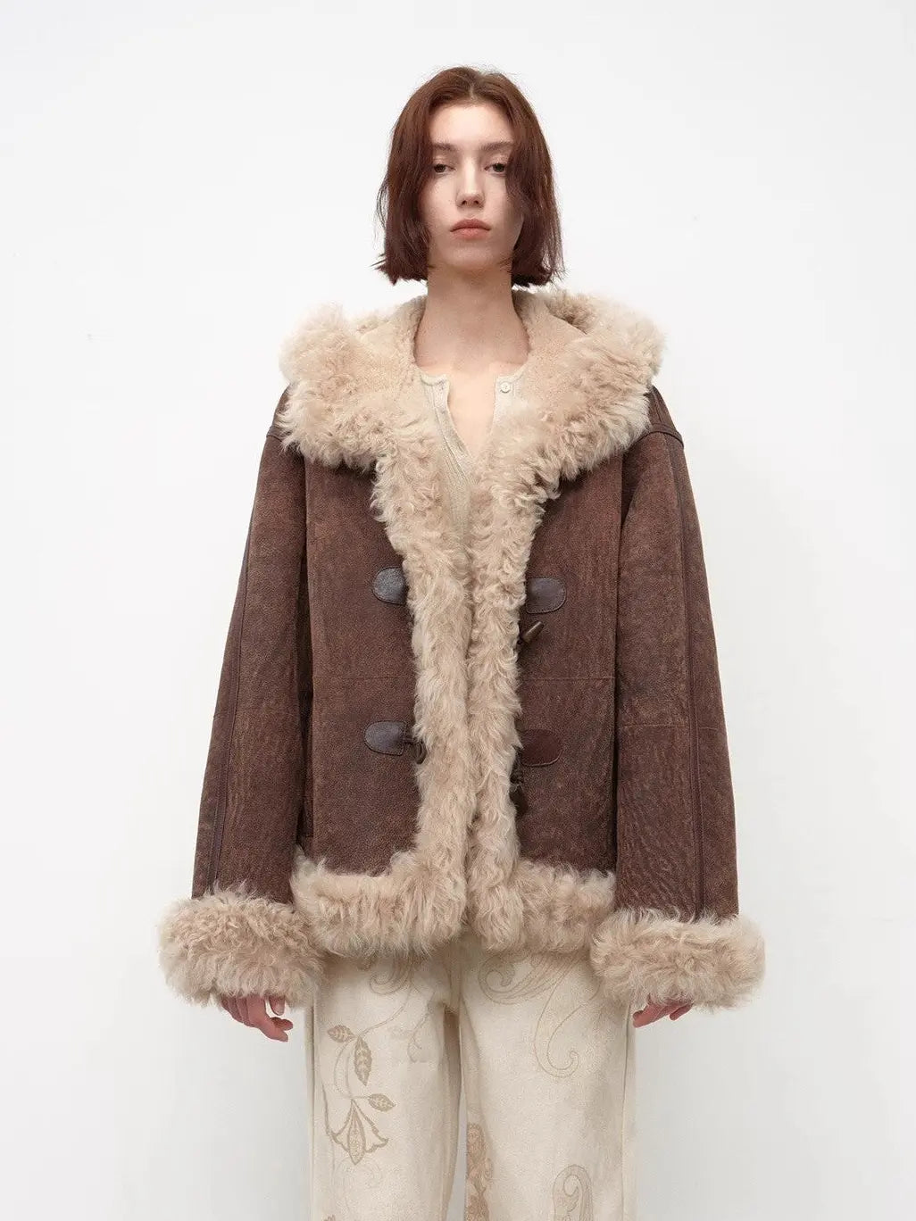 Model wearing the fog brown hooded Merino shearling jacket, view 1