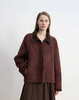 Reddish brown shearling coat showing structured winter silhouette
