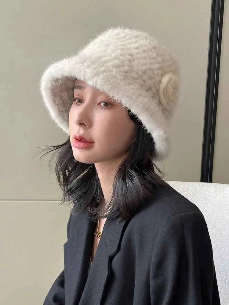 Woman wearing a white mink woven camellia bucket hat, front three-quarter view