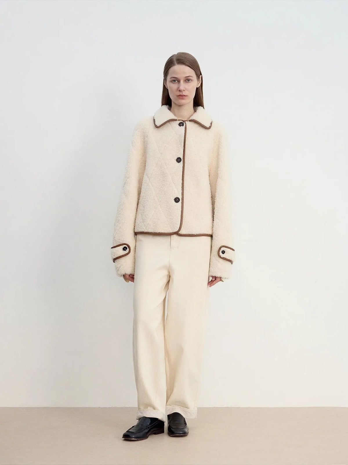 Off-white Merino shearling jacket styled with matching trousers, full-length front view