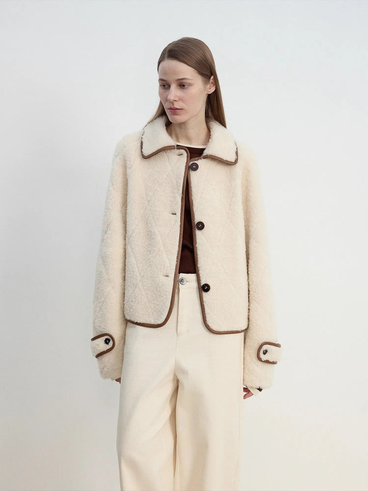 Woman modeling the off-white Merino shearling jacket, three-quarter view