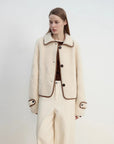 Woman modeling the off-white Merino shearling jacket, three-quarter view