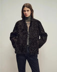 Model wearing the Mole Manor purple plum lake lamb shearling coat, mid-length view