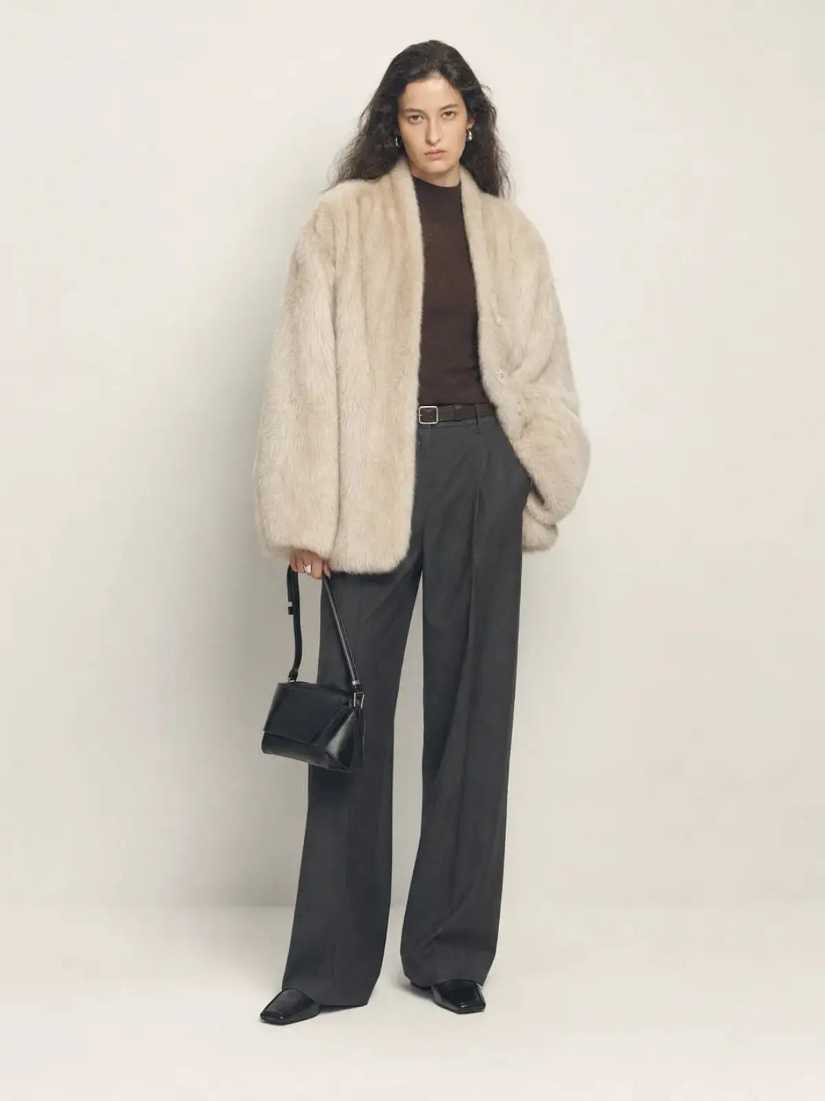 Woman styling the Night in Paris camel Toscana shearling coat, full-length view