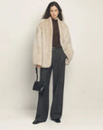 Woman styling the Night in Paris camel Toscana shearling coat, full-length view