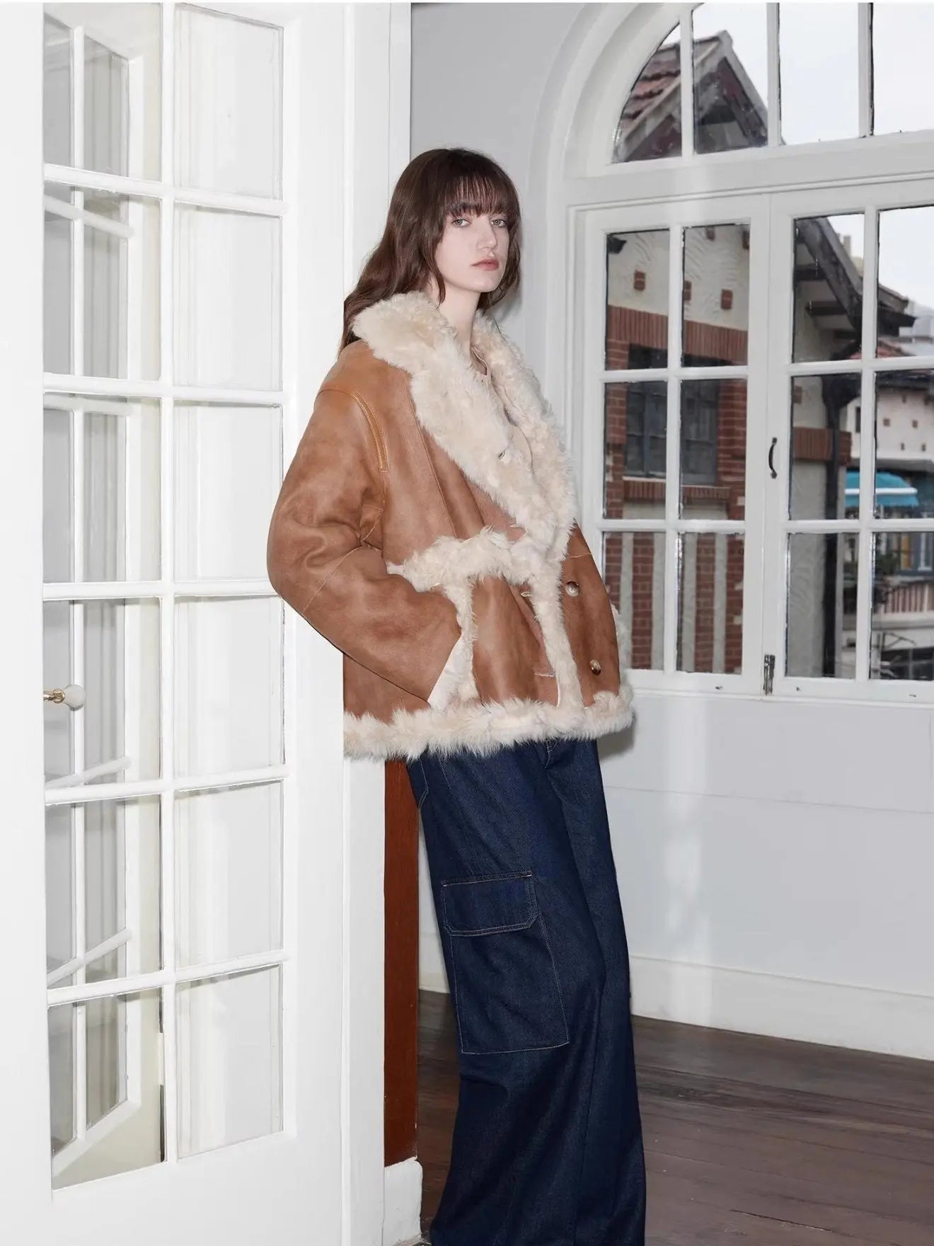 Woman styling the Oppenheimer brown Toscana shearling coat indoors