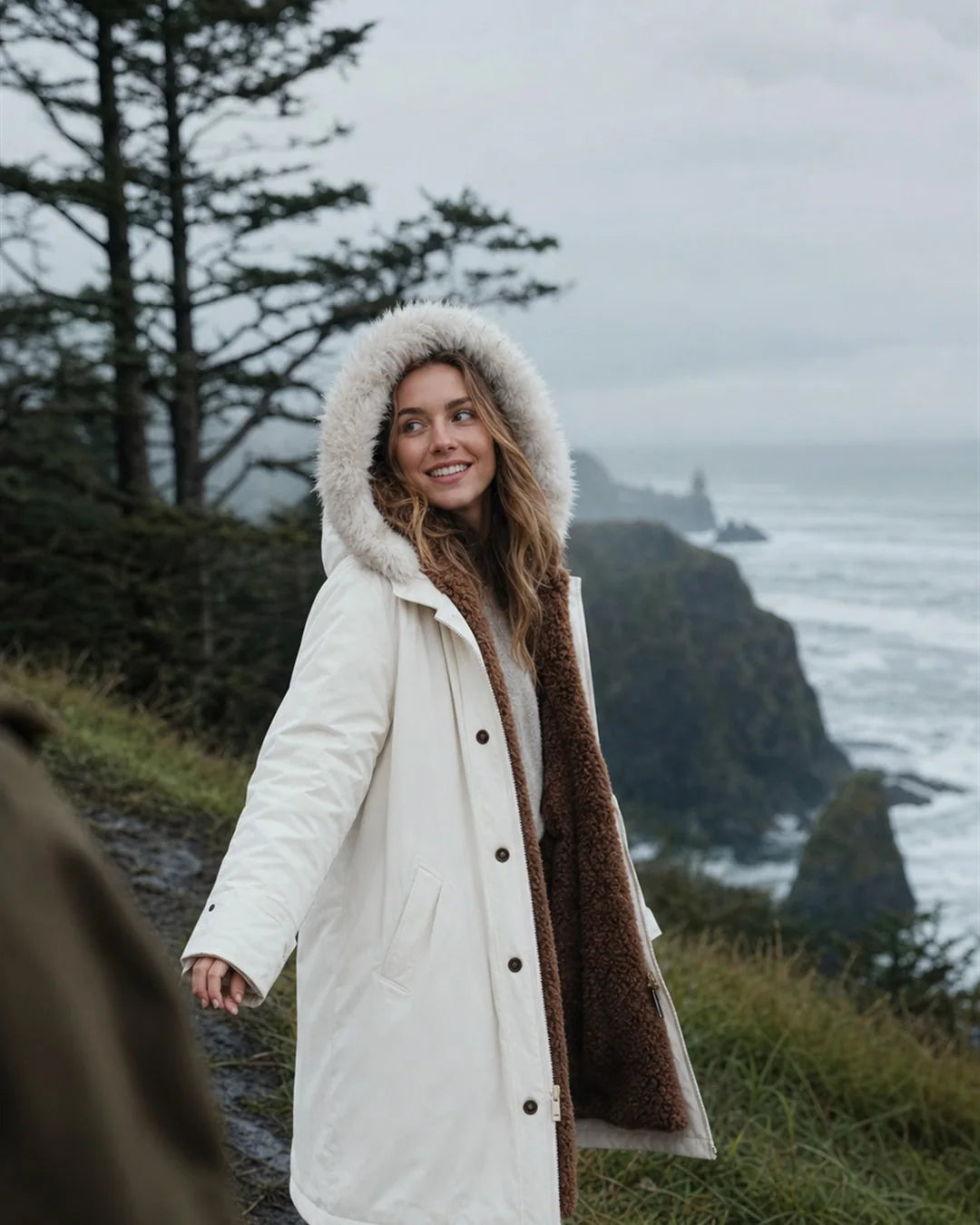 Woman wearing a hooded winter parka in exposed coastal weather