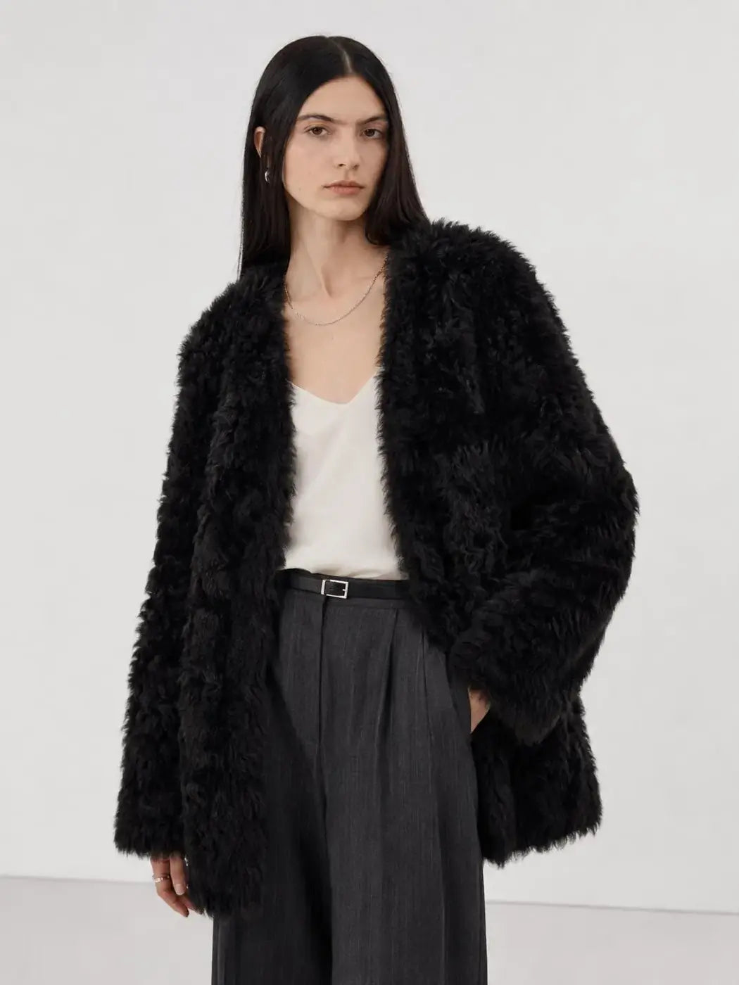 Model wearing the Peach Oolong classic black Toscana sheepskin winter coat, close front view