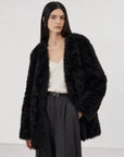 Model wearing the Peach Oolong classic black Toscana sheepskin winter coat, close front view