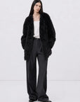 Model wearing the Peach Oolong classic black Toscana sheepskin winter coat, full-length view