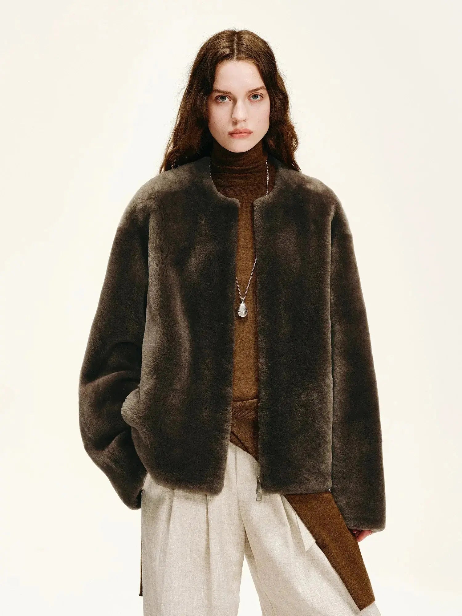 Woman wearing the Quiet Warmth dark brown Merino shearling jacket, front view