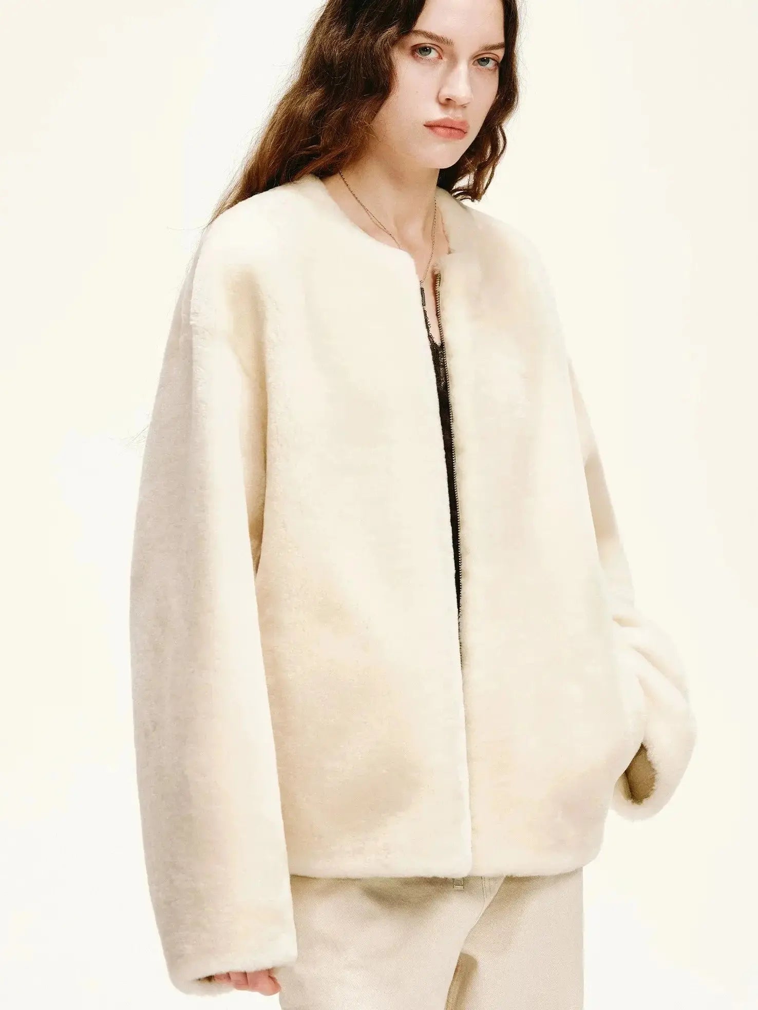 Woman styling the Quiet Warmth ivory Merino shearling jacket, three-quarter view