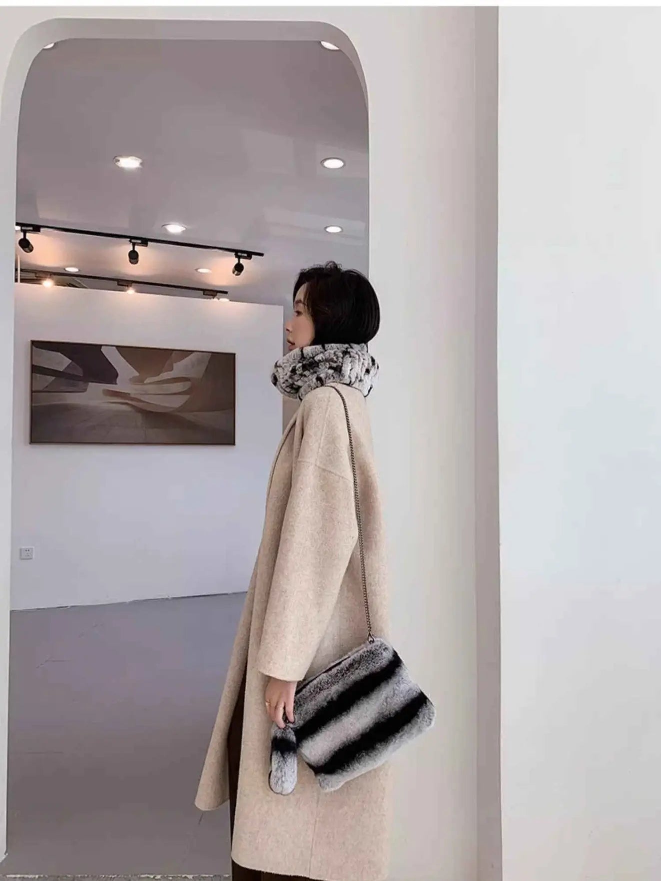 Woman wearing a grey rex rabbit fur neck scarf with an elegant winter coat