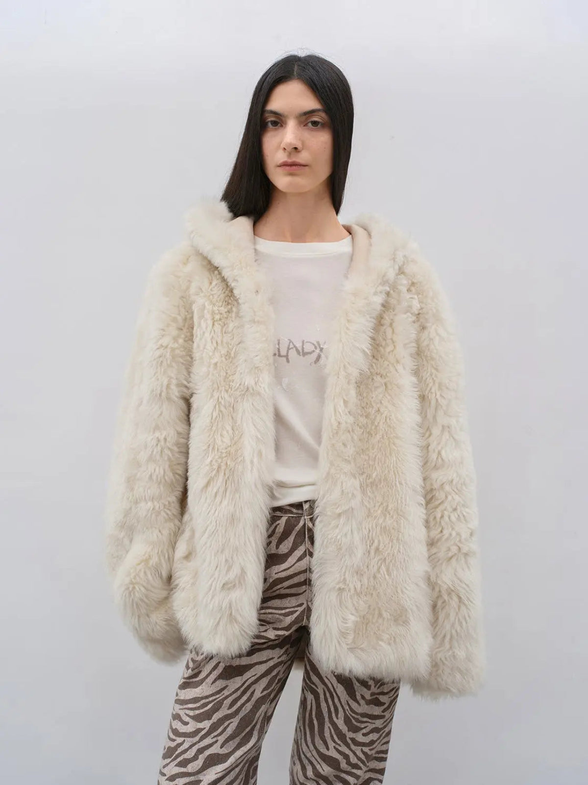 Woman wearing the Winter Snow off-white hooded Toscana shearling coat, front view
