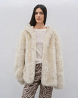 Woman wearing the Winter Snow off-white hooded Toscana shearling coat, front view